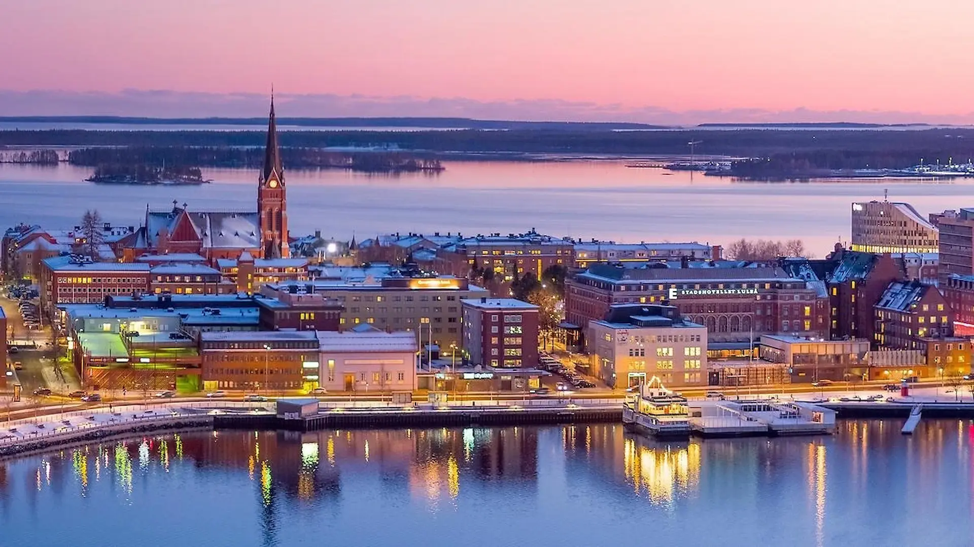 Luleå stadsbild i kvällsljus med upplysta byggnader vid Luleälven